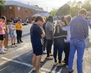  ?? AP ?? A woman embraces Antojuan Woody at a prayer vigil Sunday outside First Baptist Church in Dadeville, Ala. Woody was best friends with Philstavio­us Dowdell, who was one of four people killed in a shooting Saturday.