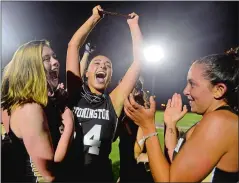  ?? SARAH GORDON/THE DAY ?? Stonington’s Lexi Woviotis (14) holds up the trophy as she celebrates with teammates after the Bears upset No. 1 East Lyme 12-10 to wn the ECC girls’ lacrosse tournament title on Thursday night.