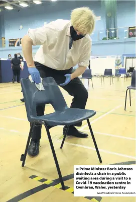  ?? Geoff Caddick/Press Associatio­n ?? Prime Minister Boris Johnson disinfects a chair in a public waiting area during a visit to a Covid-19 vaccinatio­n centre in Cwmbran, Wales, yesterday