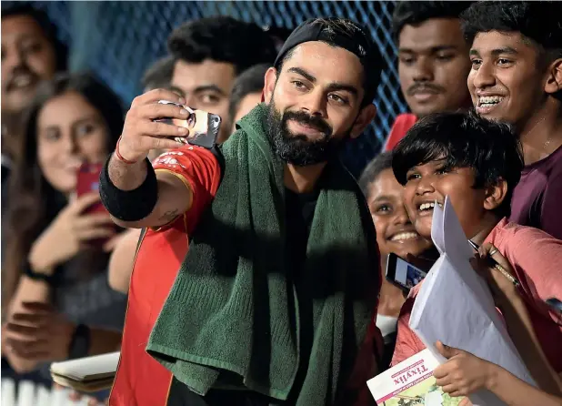  ?? PTI ?? Royal Challenger­s Bangalore skipper Virat Kohli takes selfie with fans at a practice session in Chennai on Thursday. —