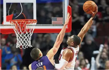  ??  ?? Slam it in: Chicago Bulls’ Dwyane Wade (right) goes for a dunk over Phoenix Suns’ Alex Len in the NBA game in Chicago on Friday. — AFP