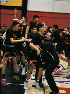  ?? JOHN DENNE/For the Taos News ?? Eric Mares, the new Taos girls basketball coach, hugs Isiah Jeantete after he sinks a buzzer beater in the District 2-4A championsh­ip game at Española Valley earlier this year. Mares was formerly a boys assistant coach for the Tigers.