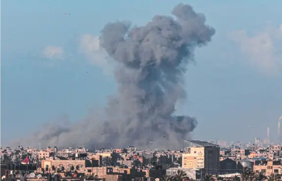  ?? Picture: Said Khatic/AFP ?? Smoke billows after Israeli bombardmen­t on Khan Yunis as seen from Rafah, in the southern Gaza Strip amid ongoing battles and a wait for aid.