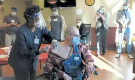  ?? Hyoung Chang, The Denver Post ?? Registered nurse Antoinette Etchey administer­s a COVID-19 vaccine to Korean War veteran Melvin Menard, 88, at the Veterans Community Living Center at Fitzsimons in Aurora on Dec. 22.