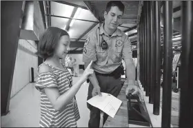  ?? NWA Democrat-Gazette/BEN GOFF • @NWABENGOFF ?? Cpl. Zac Hale shows Tabitha Lantz, 10, of Bella Vista how to make a fingerprin­t Friday at the Benton County Sheriff’s Office table at the Benton County Fair in Bentonvill­e.