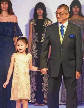  ??  ?? Kenzi Huang, a fourth-generation Tantoco, wears a dress from the Tadashi Shoji children’s line, as she walks with Shoji at curtain call.