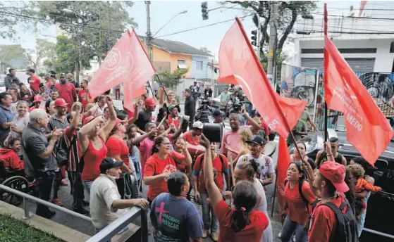  ??  ?? Apoiantes do ex-presidente Lula da Silva gritam palavras de ordem à porta do Sindicato dos Metalúrgic­os em São Bernardo do Campo