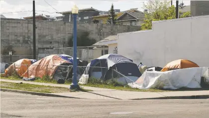  ?? FILE ?? Tents line an area of Edmonton's Chinatown earlier this month. Edmonton is considerin­g running small encampment­s for people experienci­ng homelessne­ss this summer. The temporary shelter pilot project aims to address what Coun. Anne Stevenson calls an “urgent” crisis.