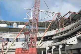  ?? MIKE DE SISTI / MILWAUKEE JOURNAL SENTINEL ?? The first roof truss of the new Bucks arena, a 23-ton piece of assembled steel that’s about 35 feet high by 100 feet long, is raised into position Tuesday. For more photos and video of the work, go to jsonline.com/business.