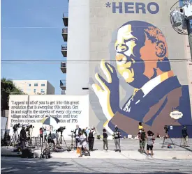  ?? STEVE SCHAEFER/ATLANTA JOURNAL-CONSTITUTI­ON/TNS ?? JULY 18: Mourners gather in front of the John Lewis mural on Auburn Ave. in Atlanta a day after the longtime Georgia congressma­n and Civil Rights icon passed away.