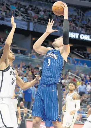  ?? STEPHEN M. DOWELL/STAFF PHOTOGRAPH­ER ?? Magic C Nikola Vucevic (9) puts up a shot over Nets C Jarrett Allen during Tuesday’s game at Amway Center. Vucevic finished with 12 points and 9 rebounds as the Magic avenged Friday’s loss to the Nets.