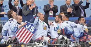  ?? PRESS ASSOCIATED ?? Josh Misiewicz (left) and other U.S. players celebrate with their gold medals after beating Canada in the Ice Hockey Gold Medal Game at the Gangneung Hockey Center in Gangneung, South Korea, at the 2018 Winter Paralympic­s on March 18.