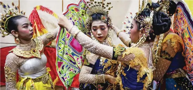  ?? — AFP ?? This photo shows women helping each other adjust their costumes before performing a traditiona­l dance during a press conference in Narathiwat to promote the Peace Cup football tournament being held between the four southernmo­st Thai provinces.