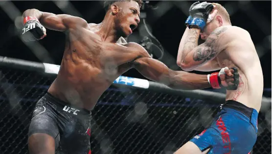  ?? JIM WELLS ?? Calgary’s Hakeem Dawodu delivers a blow to Austin Arnett en route to winning his featherwei­ght bout by unanimous decision during Saturday’s UFC Fight Night at the Saddledome.