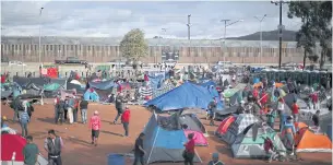  ??  ?? GROWING CRISIS: Migrants rest in temporary shelters in Tijuana amid shortages of resources.