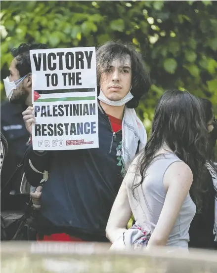  ?? ELIJAH NOUVELAGE / AFP VIA GETTY IMAGES ?? A protester holds up a sign as students demonstrat­e at Emory University in Atlanta, Ga., Thursday.