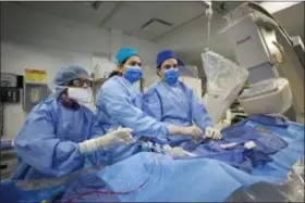  ?? MARK LENNIHAN — THE ASSOCIATED PRESS ?? In this photo, Dr. Annapoorna Kini, center, performs a non-emergency angioplast­y at Mount Sinai Hospital in New York. Through a blood vessel in the groin, she guides a tube to a blockage in the heart. She inflates a tiny balloon to flatten the clog,...