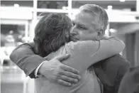  ?? Associated Press ?? ■ Jim Demetros hugs his wife, Cindy, Tuesday as she arrives from their home in Connecticu­t to pick him at Philadelph­ia Internatio­nal Airport after his Southwest Airlines plane landed with a damaged engine.