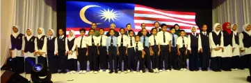  ?? — Photo by Muhammad Rais Sanusi ?? Wan Saiful (third left, back) with other invited guests sing the national anthem with the children.