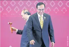  ??  ?? Now it’s your turn: Vietnamese Prime Minister Nguyen Xuan Phuc holds the gavel as Thai Prime Minister Prayut Chan-o-cha leaves the stage after handing over the Asean chairmansh­ip to Vietnam during the closing ceremony of the 35th Asean Summit in Bangkok last Monday.