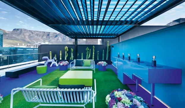 ??  ?? ABOVE The rooftop terrace bursts with bright greens and blues, complement­ed by two-seater Palissade benches created by HAY and available at Créma Design. BELOW Comfortabl­e benches – specially manufactur­ed for the balcony area – are upholstere­d in fabric by Hertex. OPPOSITE “Although several colours are used together in one space, they have muted undertones to create an overall feeling
of calm,” says Etienne.