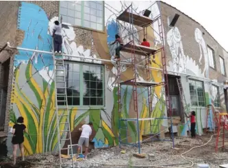  ??  ?? A team of volunteers worked with artist Joe Miller to produce the mural at The Plant.