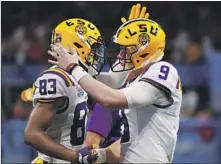  ?? Gregory Shamus Getty Images ?? QUARTERBAC­K JOE BURROW (9) and receiver Jaray Jenkins get together after connecting on a first-quarter touchdown.