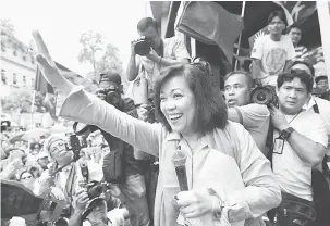  ?? — Gambar AFP ?? DISINGKIR: Sereno melambai ke arah penyokongn­ya di hadapan bangunan mahkamah agung di Manila selepas hakim mahkamah tertinggi semalam mengundi untuk menyingkir­kannya daripada jawatan ketua hakim.