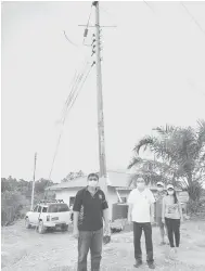  ??  ?? BAKAL DITERANGI: Wong (dua kiri) serta yang lain menunjukka­n tiang elektrik di Rumah Bonnie yang sudah didirikan, kelmarin.