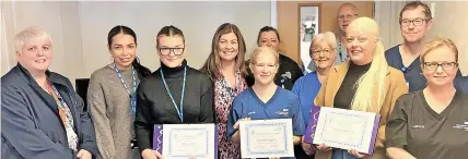  ?? ?? Megan Bell and Victoria Webster, third from left and third from right, with their apprentice­ship awards supported by colleagues.