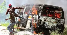  ?? (Reuters) ?? SUPPORTERS OF Kenyan opposition National Super Alliance gesture near a burning vehicle in Embakasi, near Nairobi, yesterday.