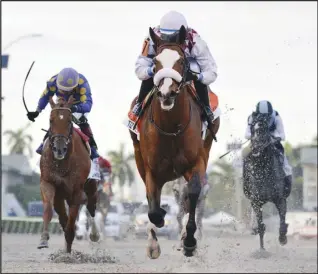  ?? Associated Press ?? RUNNING STRONG — In this March 28 image provided by Gulfstream Park, Tiz the Law, ridden by Manuel Franco, foreground, runs in the Florida Derby horse race at Gulfstream Park in Hallandale Beach, Florida. Tiz the Law looks every bit like the best 3-year-old in the world and is the Triple Crown favorite, so it’ll take something spectacula­r from a watered-down field to prevent him from becoming the first New York-bred horse to win the Belmont in over 130 years and take a powerful stride toward the Kentucky Derby.