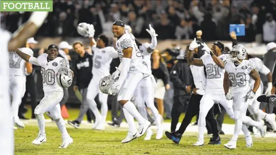  ?? John Sleezer / TNS / Kansas City Star ?? Jalen Richard (30), Xavier Woodson-Luster (56), Sean Smith (21) and DeAndre Washington (33) rejoice after the Raiders defeated the Chiefs on Thursday night.