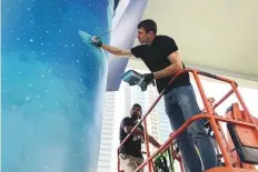  ?? Shafaat Shahbandar­i/Gulf News ?? Ukrainian artist Yevgen Trofymchuk giving final touches to a mural on a Dubai Metro pillar on Shaikh Zayed Road.