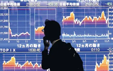  ?? REUTERS ?? A man looks at an electronic stock quotation board showing Japan’s Nikkei average outside a brokerage in Tokyo.