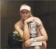  ?? Pool / Getty Images ?? Maria Sharapova poses with the Coupe Suzanne Lenglen trophy after winning the 2014 French Open. Sharapova retired from tennis on Wednesday.