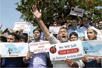  ?? — AFP photo ?? Protesters shout slogans during a second day of a strike called by Kashmiri separatist­s against attempts to revoke state constituti­on articles 35A and 370 in Srinagar.