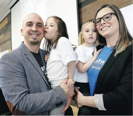  ?? NICK BRANCACCIO ?? Hazel Seguin, 5, snuggles with her dad, Matt Seguin, while her sister Nola, 3, is held by mom Stephanie Seguin during launch of The Chasing Hazel Foundation on Monday. The foundation aims to advocate for children born with Down syndrome and provide...