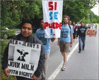  ?? Associated Press photo ?? Scores of dairy farm workers and activists march in Montpelier, Vt., on Saturday. They were marching to the main Ben & Jerry's factory in the Vermont town of Waterbury to protest what they feel are slow negotiatio­ns to reach a deal on their “Milk with...