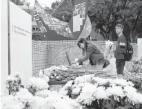  ?? REUTERS ?? Students pay tribute with flowers to Chow Tsz-lok, 22, a university student who fell during protests at the weekend and died early on Friday morning, at the Hong Kong University of Science and Technology, in Hong Kong on Friday.