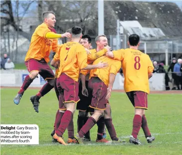  ??  ?? Delight Gary Brass is mobbed by teammates after scoring Whitburn’s fourth