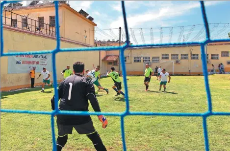  ?? MARIOS LOLOS / XINHUA NEWS AGENCY ?? Inmates play soccer against sports reporters at Korydallos Prison in Athens on Tuesday.