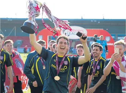  ?? Picture: SNS Group. ?? Arbroath’s Jassem Sukar with the League Two trophy as the Red Lichties celebrate their title success at Stirling at the weekend.