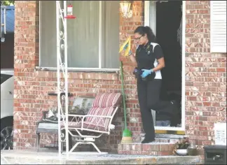  ?? The Sentinel-Record/Richard Rasmussen ?? SHOOTING DEATH: Jennifer Barrera, Hot Springs police crime scene investigat­or, works to process the scene of a fatal shooting Tuesday morning at 101 Carla Circle, located off Winans Avenue.