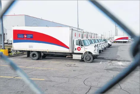  ?? CP PHOTO ?? Idle Canada Post trucks sit in the parking lot of the Saint-Laurent sorting facility in Montreal as rotating strikes hit the area on Thursday.