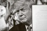  ?? Samuel Corum / New York Times ?? President Donald Trump holds up one of multiple executive orders he signed Friday designed to lower prescripti­on drug prices for consumers.