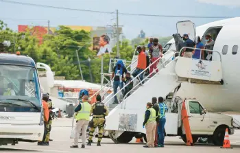  ?? ODELYN JOSEPH/AP ?? Haitians who were deported from the United States disembark Sept. 19, 2021, at the Toussaint L’Ouverture Internatio­nal Airport in Port au Prince, Haiti. More than 20,000 Haitians have been deported from the U.S. in the past year.