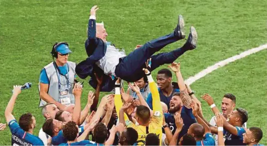  ??  ?? Deschamps dilambung pemain Perancis untuk meraikan kejayaan menjuarai Piala Dunia, di Russia.