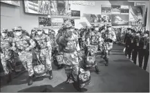  ?? ZHU XINGXIN / CHINA DAILY ?? Visitors look at a group sculpture depicting medical personnel from the People’s Liberation Army supporting Wuhan, Hubei province, during the height of the COVID- 19 outbreak, as the exhibition opens on Thursday.