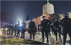  ?? Lucy Sherriff for The National ?? Police cordon off Trump fans from left-wing protesters outside the Oregon State Capitol building